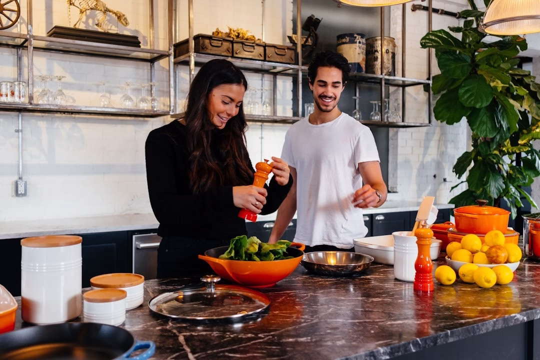 vrouw en man die koken in een keuken tijdens een kookworkshop